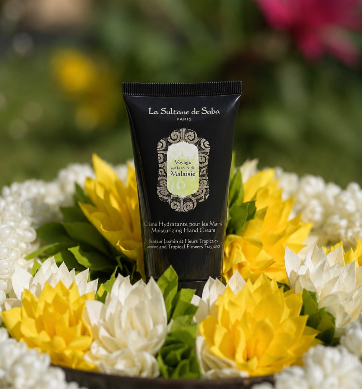 Jasmine & Tropical Flowers moisturizing hand cream displayed among white and yellow flowers